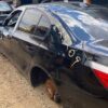 A black car that has been smashed in the back.