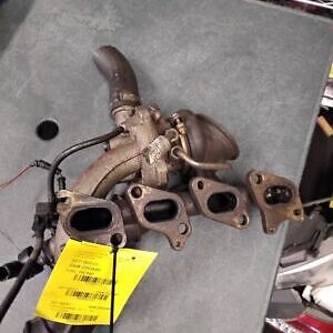 A pair of exhaust manifolds are sitting on the floor.