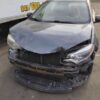 A car that has been smashed in front of a truck.