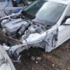 A car that has been wrecked in the mud.