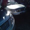 A car parked in the sun with another car behind it.