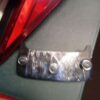 A piece of metal is attached to the back of a car.