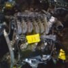 A car engine that is sitting in the dirt.