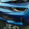 A blue car that has been smashed in the side of it.