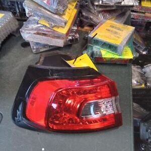 A red and black car tail light on top of a table.