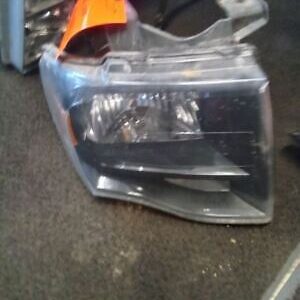 A car headlight that is broken and sitting on the floor.