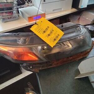 A car headlight with a yellow tag hanging from it.