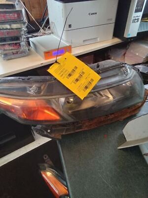 A car headlight with a yellow tag hanging from it.