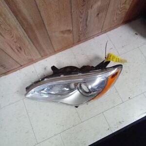 A car headlight sitting on the floor of a room.