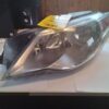 A car headlight with the hood up.