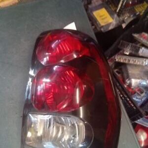 A red and black truck tail light sitting on top of a table.