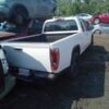 A white pick up truck parked in the middle of a lot.