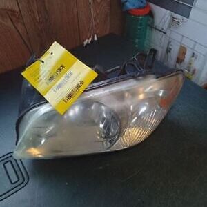 A car headlight with a yellow sticker on it.