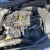 A car engine with the hood open and the yellow cap.