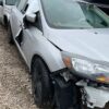 A silver car that has been smashed in the side of it.
