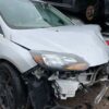 A white car that has been smashed in the back of it.