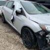 A silver car with its front end broken off.