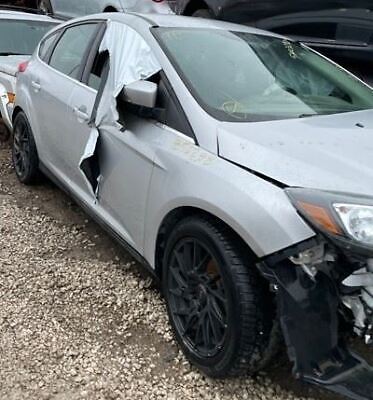A silver car with its front end broken off.