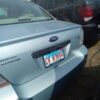 A silver car with a license plate on it.