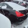 A black car parked in the snow with red lights on it.