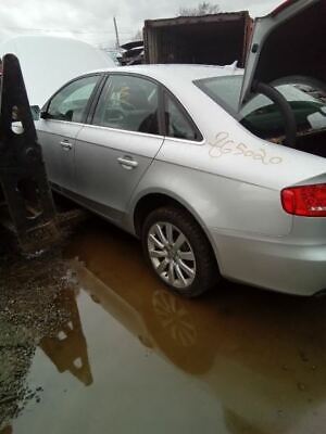 A silver car parked in the middle of a flooded street.