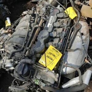 A pile of old car parts with some yellow tags on it.