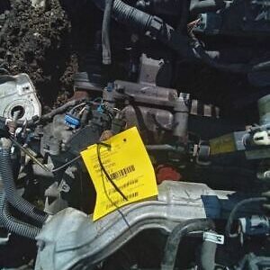 A pile of old car parts with a yellow tag on it.