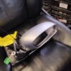 A car mirror that is broken and sitting on the leather couch.