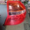 A red car tail light on the side of a vehicle.