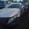 A white car that has been smashed in the middle of a road.