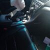 A person is sitting in the driver 's seat of an automobile.