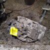 A car that is broken down and has some parts missing.