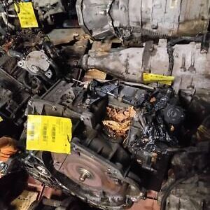 A pile of old engines and parts with yellow tags on them.